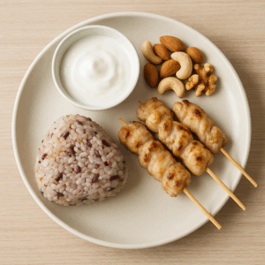 雑穀おにぎり、焼き鳥(塩控えめ)、無糖ヨーグルト、素焼きナッツを組み合わせたバランス良いワンプレート。